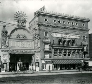 Exterior of Lubin and Bijou Theaters. The Lubin has bicycles out front and the Bijoy has a horse and cart out front.