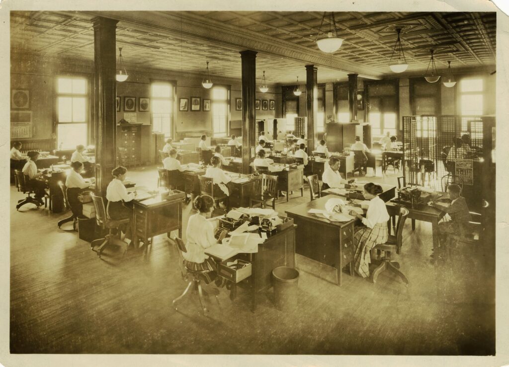 A room full of women sitting at desks working. 