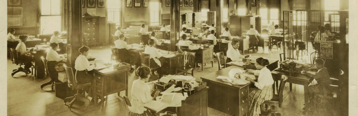A room full of women sitting at desks working.