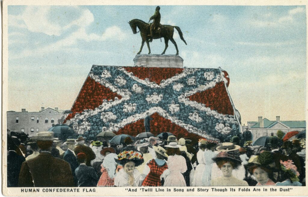 People standing in a confederate flag formation around a monument.