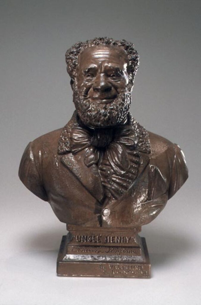Bronze bust of a well-dressed African American older man with a full beard. He is smiling. Inscription reads "Uncle Henry: Ancien Regime" by Edward Valentine.