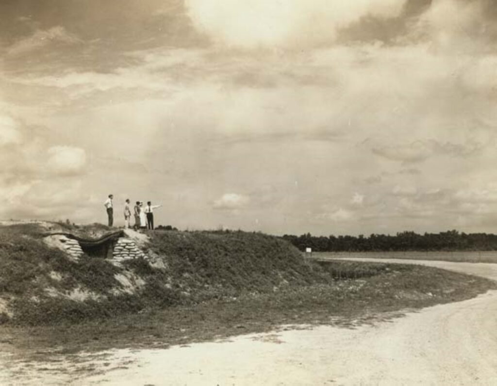 A group of 5 or so people stands on a hill at Fort Harrison.