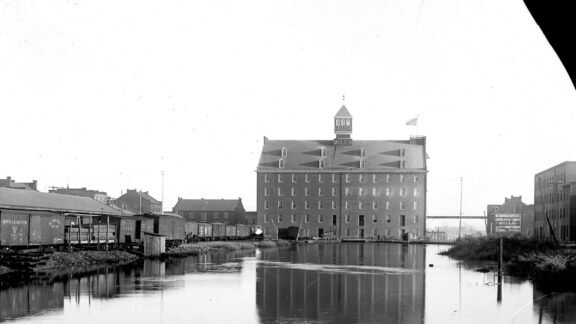 The turning basin in Richmond’s canal bordered by the five-story Gallego Flour Mills building, a railroad cars, and other industrial buildings.