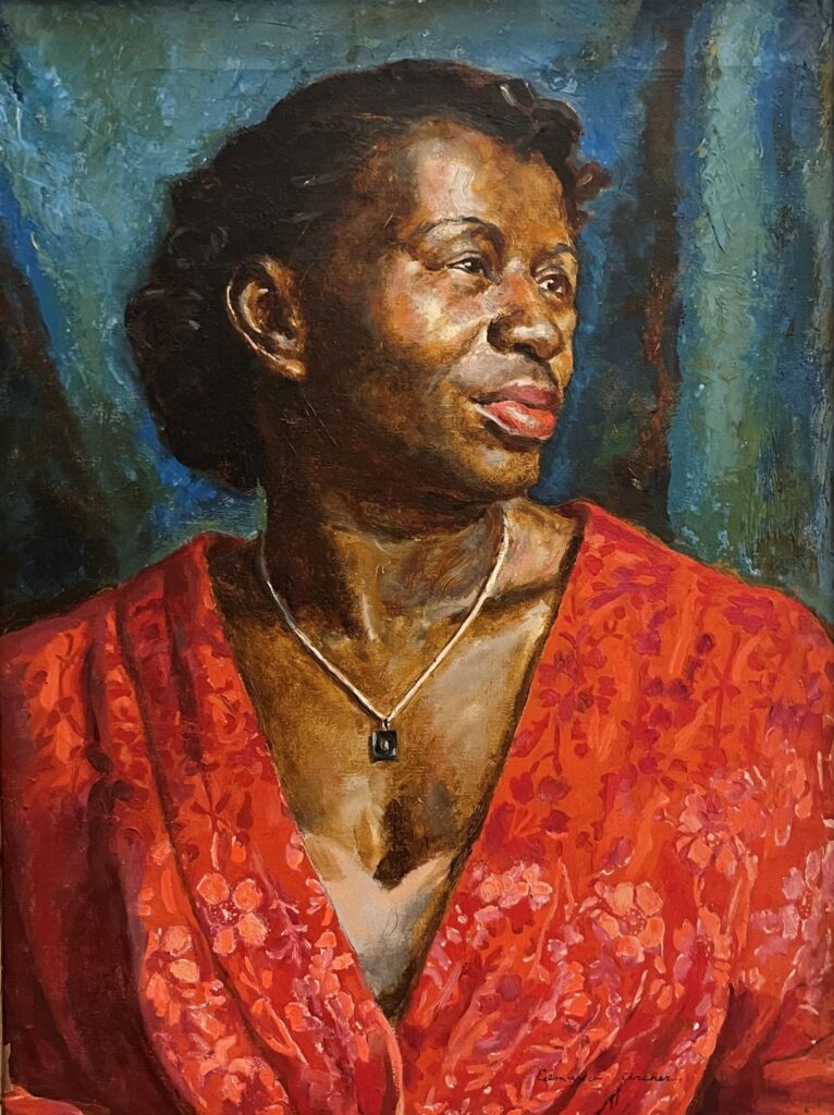 Portrait of a Black woman with a pendant necklace wearing a red top or dress.